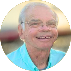 man with glasses smiling at sunset