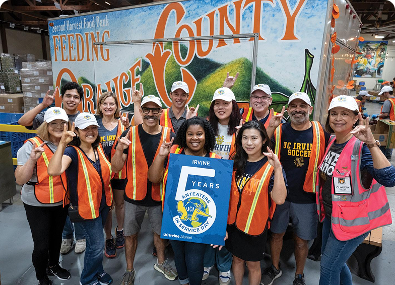 group of volunteers in front of a sign reading "feeding orange county"