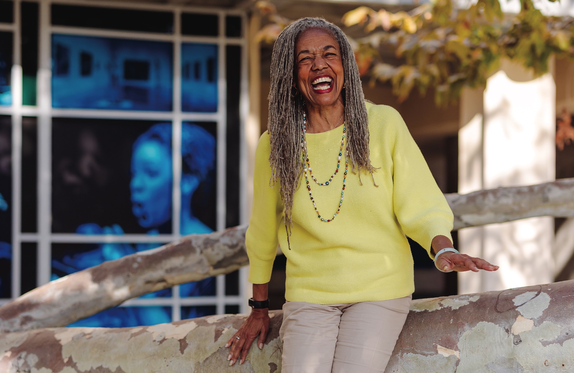 Mary Watson-Bruce, Ph.D. ’82 sitting on a tree branch and smiling
