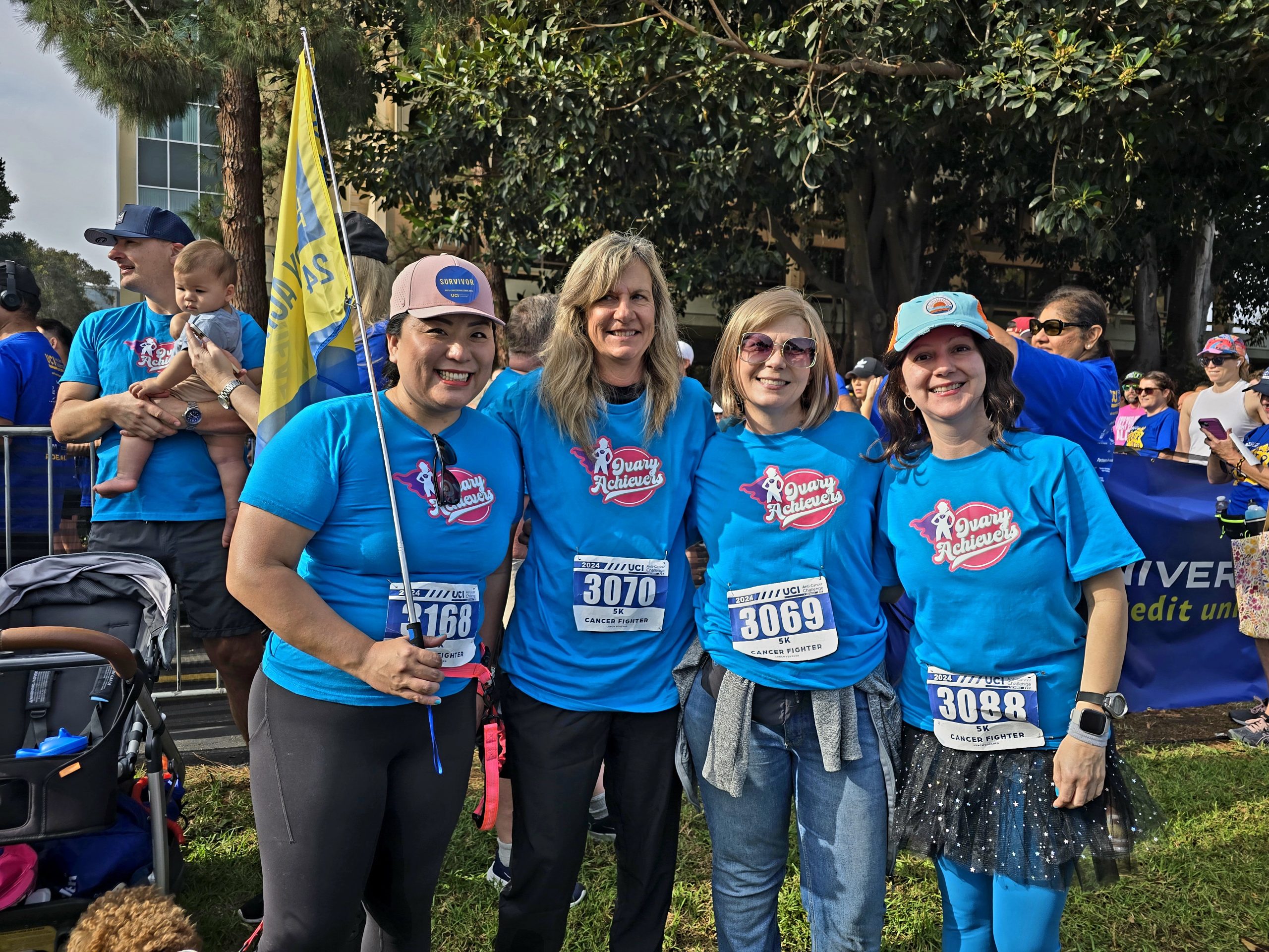 Four women in blue shirts posing at the Anti-Cancer Challenge