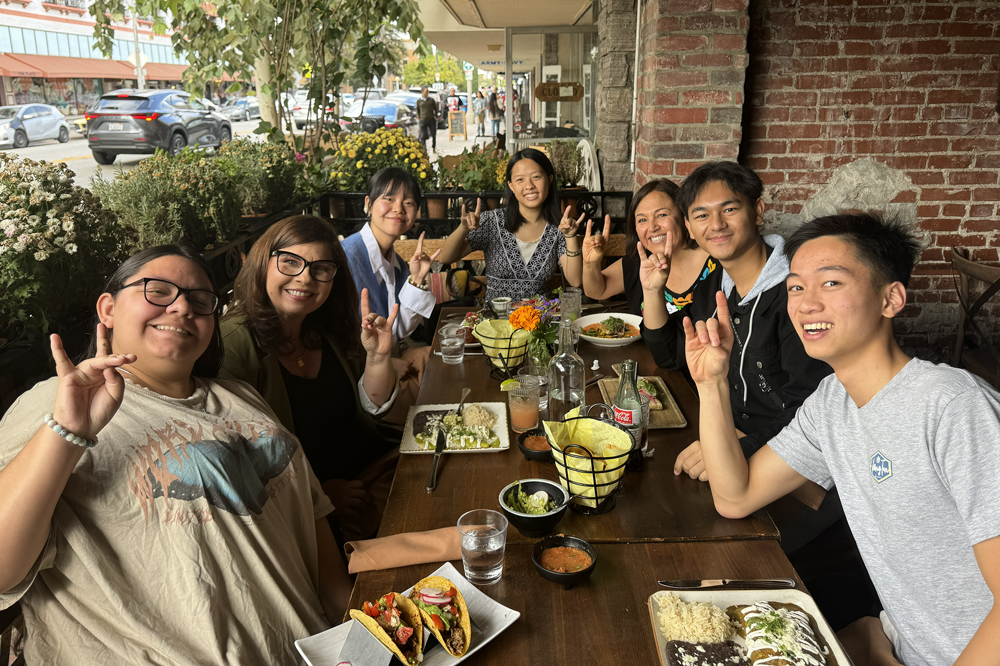 Group of students at a table sharing a meal with alumni