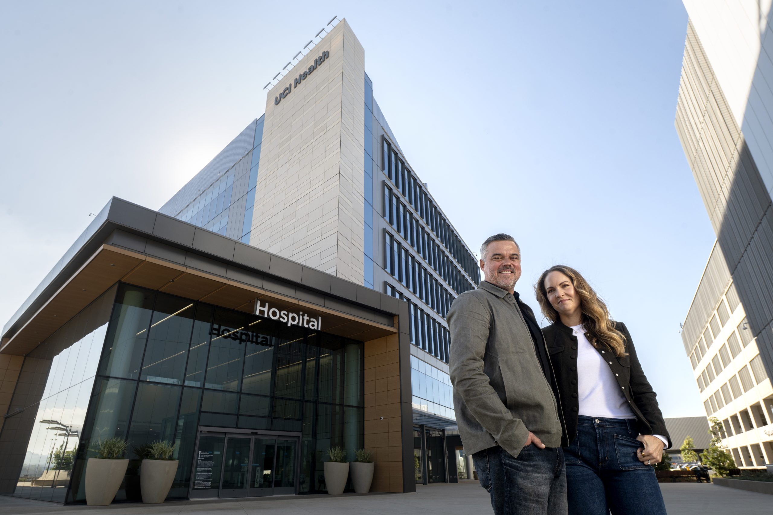 A couple poses in front of a university hospital building