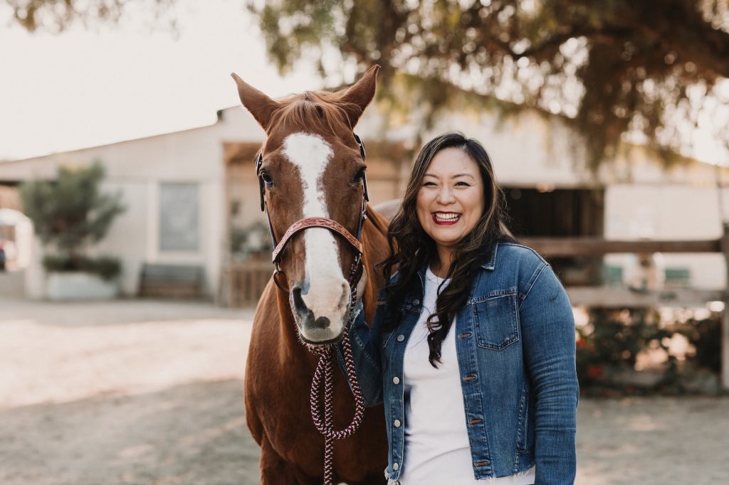 Megan Yoo Schneider ’12, M.S. ’14 posing with a horse