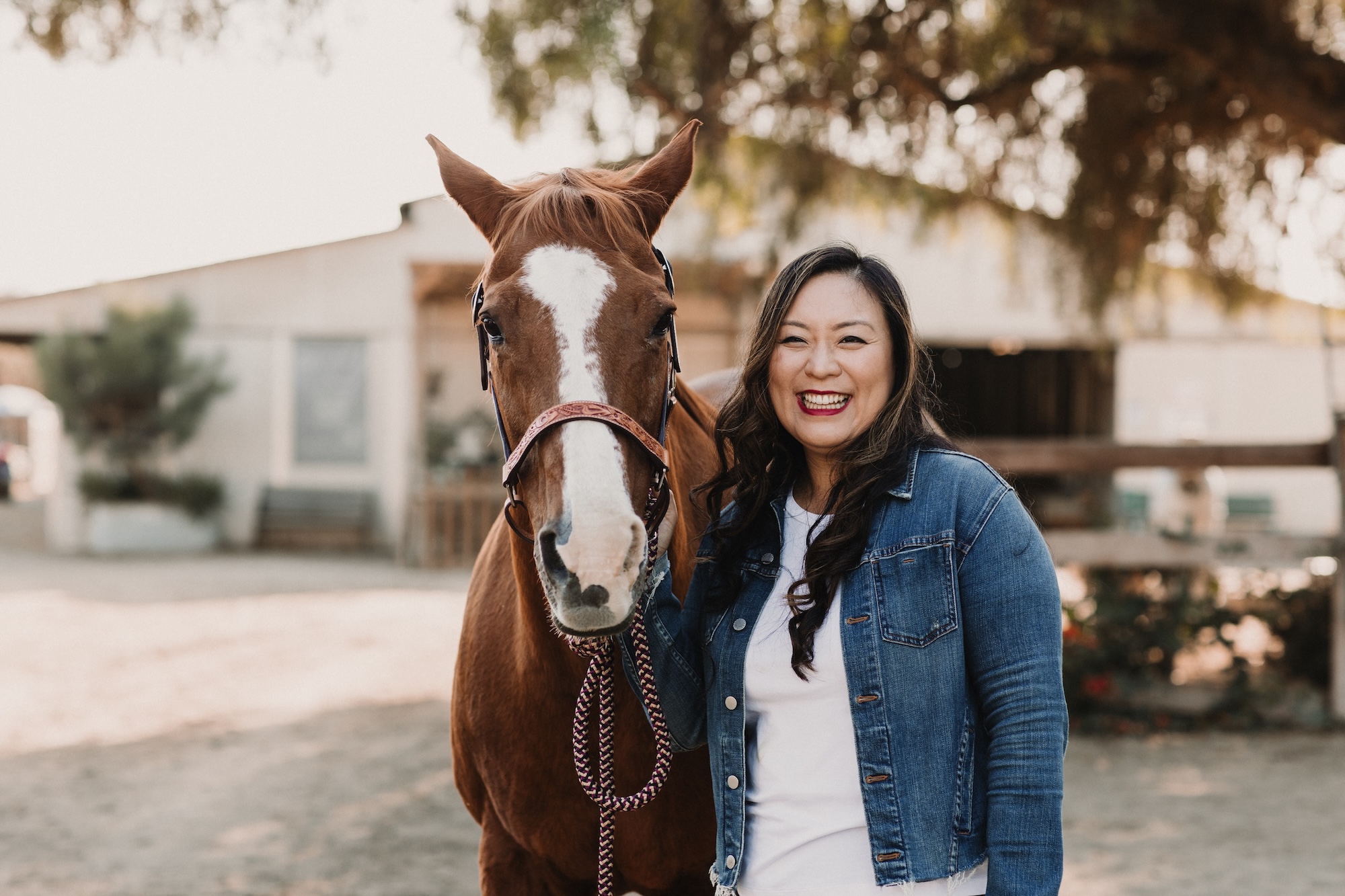 Megan Yoo Schneider ’12, M.S. ’14 posing with a horse