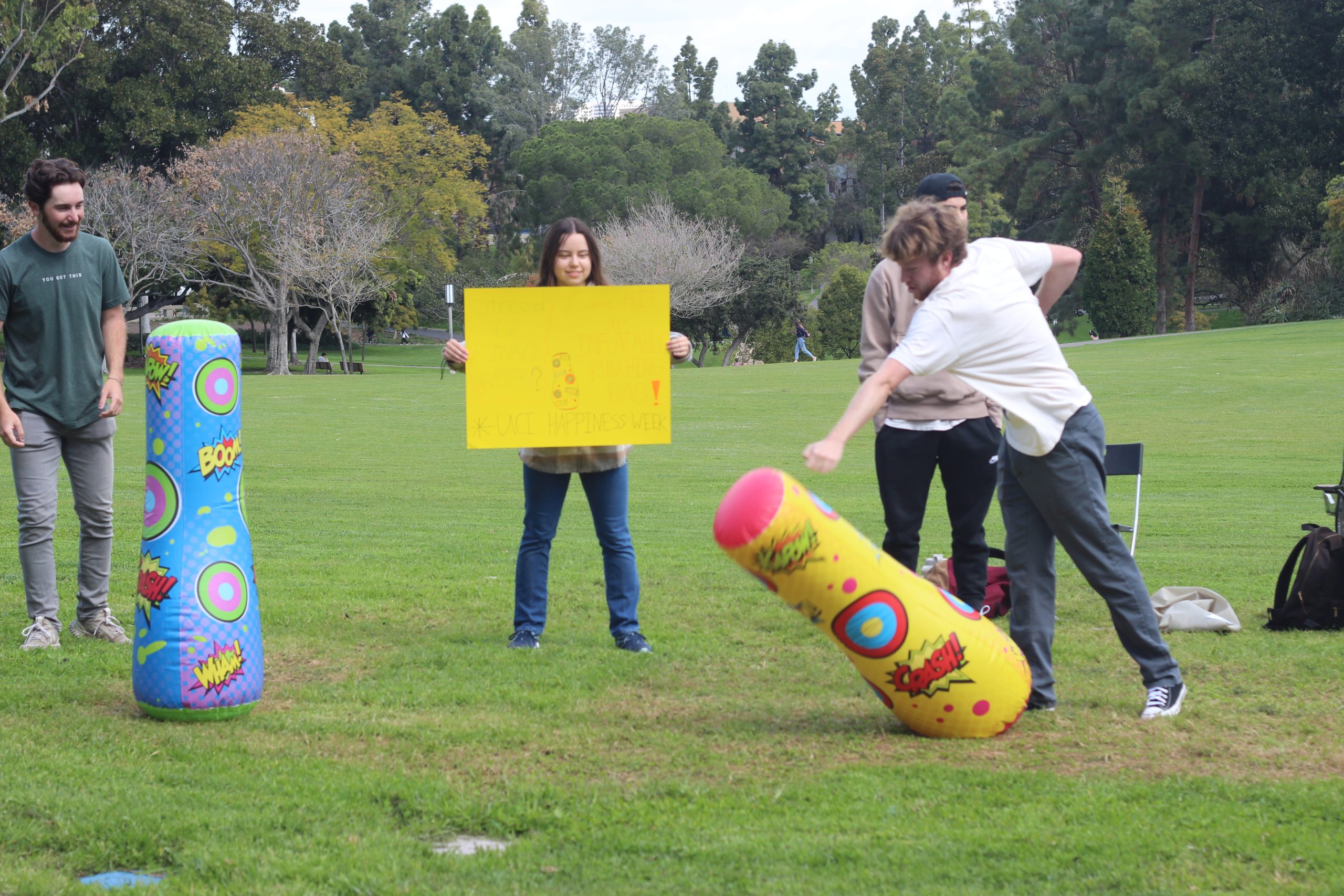 A student punches a punch bag on the lawn during Happiness Week