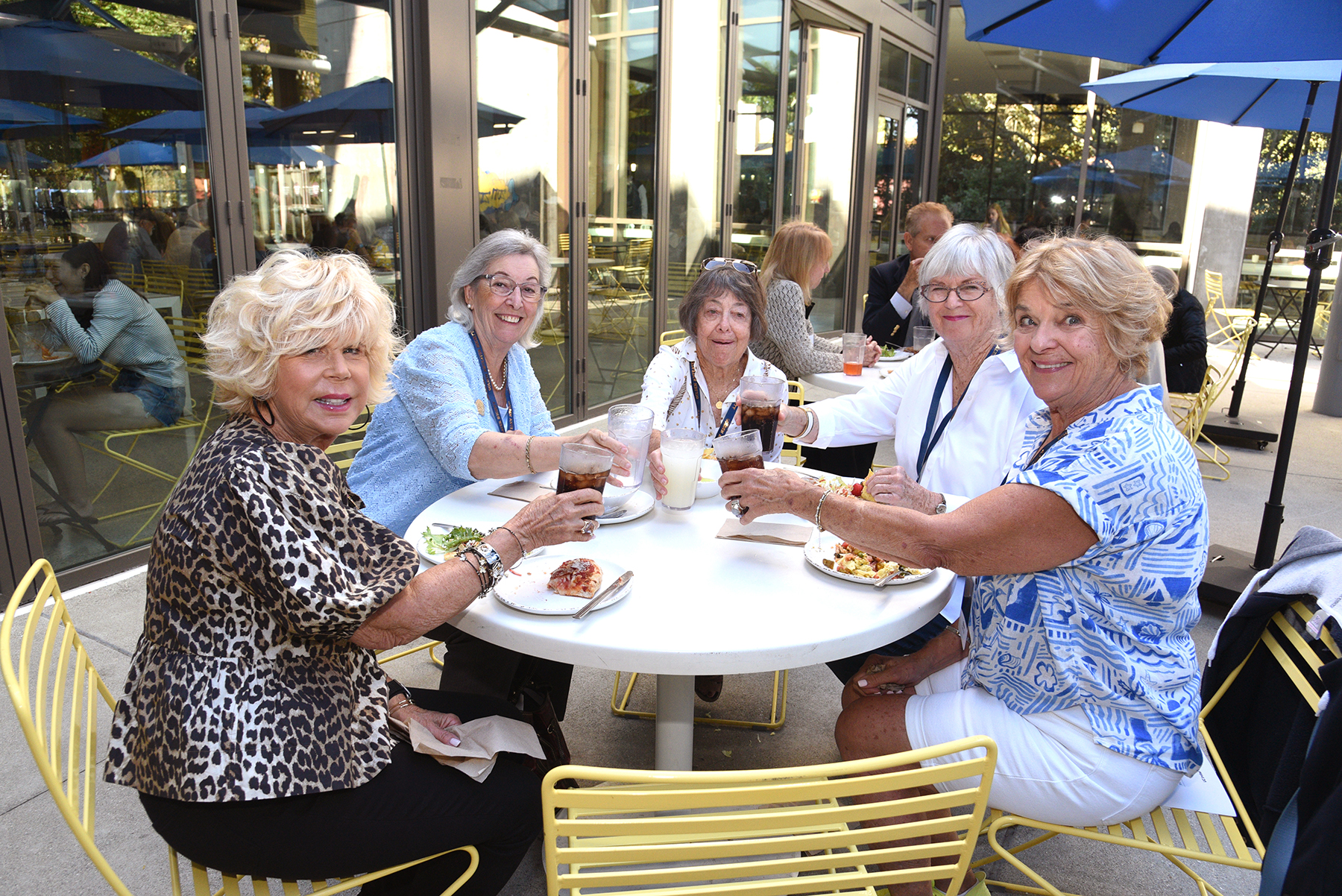 Attendees gather around an outdoor table during a UC Irvine Alumni Golden Anteater Society celebration.